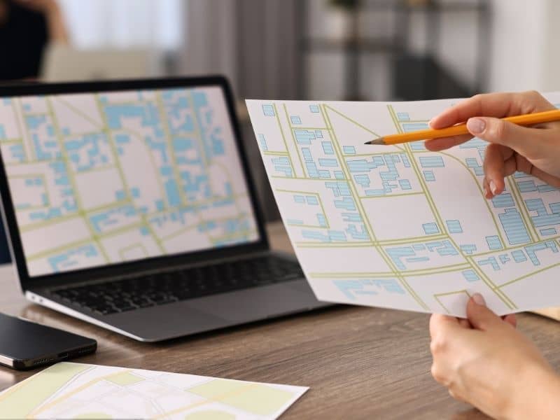 Property owner reviewing a land survey map and property details on a laptop while checking boundary information